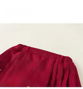 Detail of red brocade fabric with golden embroidery and elastic waist on the dress