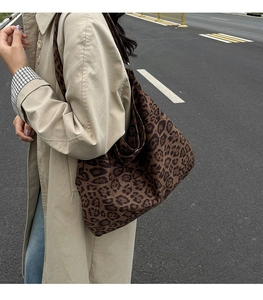 Primo piano della borsa tote leopardata con tracolla larga in un ambiente esterno urbano