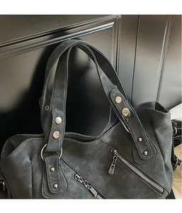 Détail d'un sac cabas vintage gris avec fermetures éclair et rivets métalliques argentés