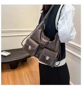 Detailed side view of deep brown large tote bag with dual front silver buckle pockets