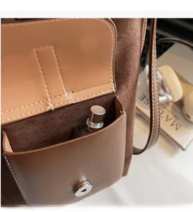 Detailed macro view of the brown leather front pocket with magnetic snap and storage space