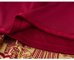Detailed view of the red velvet fabric and gold floral jacquard texture of the jacket