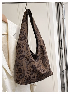 Close-up of vintage brown paisley hobo bag hanging on a minimalist metal hanger