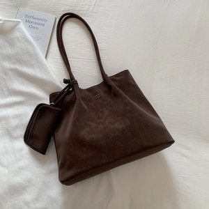 Large dark brown leather tote bag with shoulder straps and matching mini pouch bag