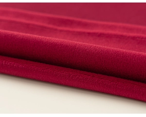 Macro detail of high-density deep red fleece fabric showing thick and soft texture
