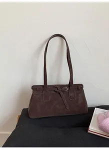 Nahaufnahme der braunen Wildledertasche mit dekorativen Gürtelriemen und Silberschnalle