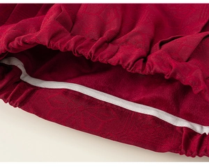 Detailed macro view of red brocade fabric texture and elastic waistband of the down jacket