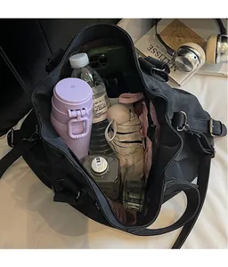 Vue de dessus d'un grand sac cabas noir montrant l'intérieur spacieux et les articles de voyage