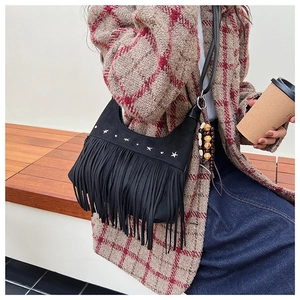 Detail of black fringe crossbody bag with silver star studs and wooden bead charms