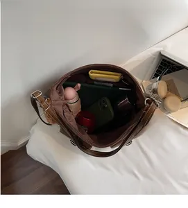 Spacious brown leather tote bag interior showing capacity for tablet, umbrella, and wallet