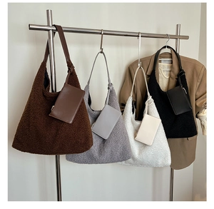 Detail view of plush shoulder bags in four colors hanging on a modern metal display rack