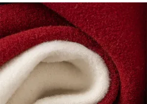 Close-up of thick red wool fabric with warm white faux shearling fleece lining