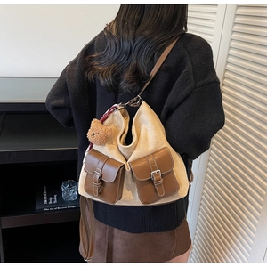 Detail view of retro beige suede and brown leather tote bag with cute bear charm
