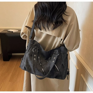 Détail du sac cabas rétro gris foncé porté avec un trench pour un style minimaliste