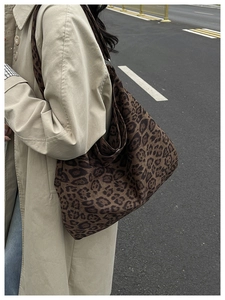 Dettaglio di una borsa tote in tela leopardata abbinata a un trench kaki per la moda autunnale