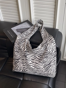 Large capacity zebra print tote bag with thick canvas strap on leather background