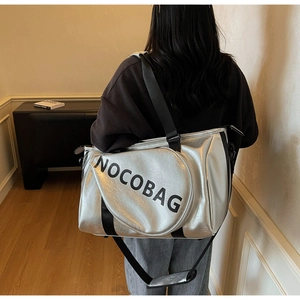 Dettaglio della borsa tote argento metallizzato con logo e tracolla in nylon