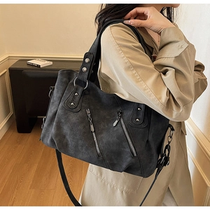 Vue détaillée du sac cabas gris foncé avec fermetures éclair et rivets métalliques