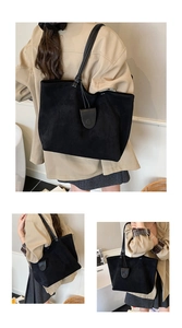 Detail of large black suede tote bag featuring slim knotted straps and minimalist oval flap