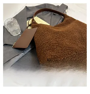 Detailed view of brown sherpa tote bag with faux leather strap and small matching pouch