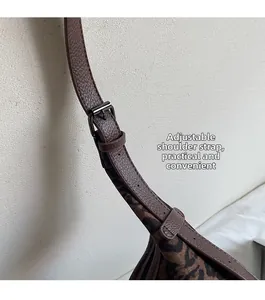 Detail des verstellbaren braunen Leder-Schultergurts mit Metallschnalle am Leopard-Tote