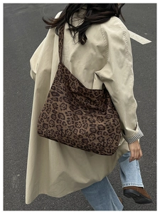 Dettaglio della borsa tote leopardata con tracolla larga su un outfit casual urbano