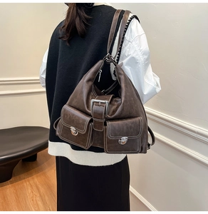 Close-up of vintage brown tote bag with retro pockets, metal buckles and stitching detail