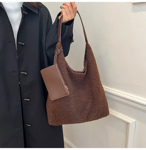 Detailed macro view of soft brown faux fur texture and brown leather strap on tote bag