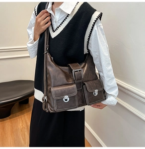 Detail view of coffee brown vintage leather tote with decorative belts and metal buckles