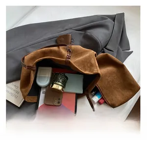 Top-down view of a spacious brown suede tote bag showing internal storage for a tablet and phone