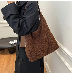 Brown fleece tote bag with leather strap shown on a model in a black winter coat