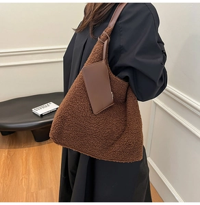 Detail of dark brown plush tote bag with faux fur texture and matching leather small pouch