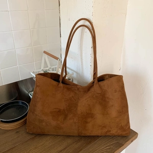Detailed texture of brown suede tote bag featuring fine velvet finish and slim shoulder straps