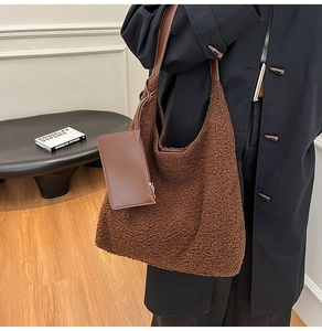 Detail of dark brown faux shearling tote bag with leather strap and detachable small pouch