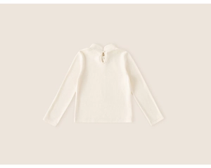 Detail of cream white turtleneck kids top with back keyhole cutout and pearl button closure