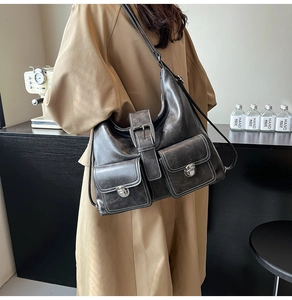 Detail of grey vintage PU leather tote with multiple functional metallic buckles