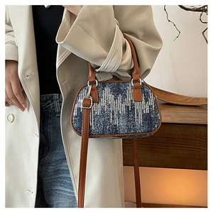 Detail of blue denim crossbody bag with silver sequins and brown leather straps