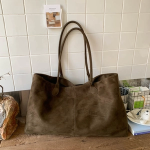 Detailed macro view of large brown suede tote bag featuring premium matte texture
