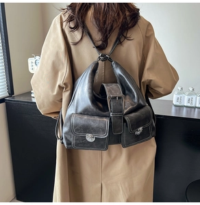 Detail of grey vintage large capacity backpack with pockets on khaki trench coat