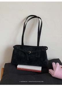 Detail der schwarzen Wildleder-Schultertasche mit Metallschnalle und Retro-Lederriemen