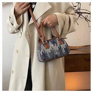 Detail of blue denim shoulder bag with silver sequins and brown leather straps