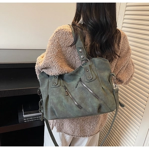 Détail du sac cabas en daim vert foncé avec trois fermetures éclair et quincaillerie argent