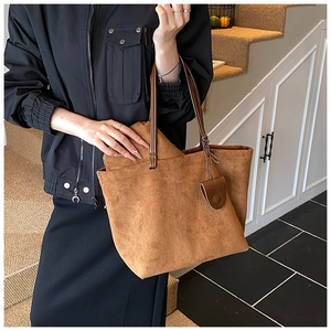 Detail showing the spacious interior and inner zipper pocket of the brown suede tote bag
