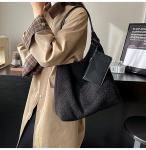 Detail view of black faux shearling tote bag texture and hanging zipper coin purse
