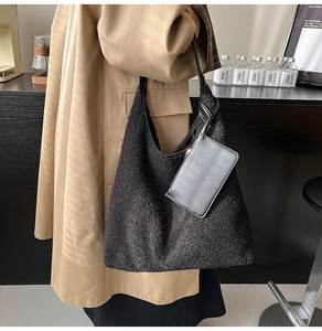 Detail of black fuzzy fleece tote bag with leather handle and matching coin purse