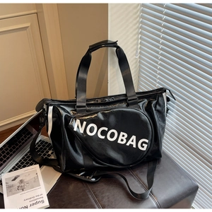 Borsa sportiva nera lucida con scritta NOCOBAG su una panca in pelle in luce naturale