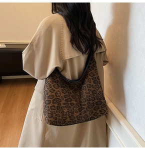 Rückansicht eines Modells mit der großen Hobo-Tasche mit Leopardenmuster zum Trenchcoat