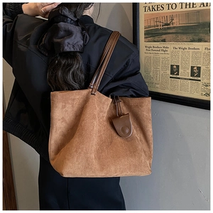 Brown suede tote bag shown on shoulder, displaying large capacity and vintage style