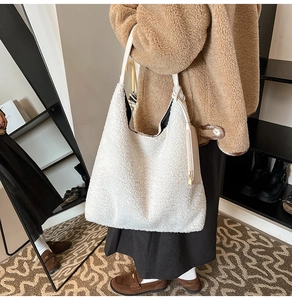 Detail of white faux shearling tote bag with leather strap and mini pouch attachment