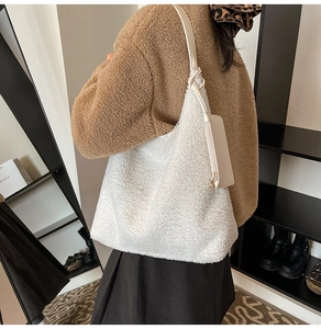 Detail of white faux shearling tote bag with beige leather strap and small side pouch